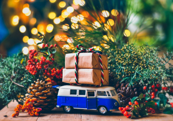 Christmas gifts wrapped in kraft paper stacked on toy camper van